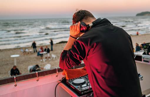 Ein DJ heizt der Menge ein bei der Saisonabschluss-Party am Strand von Binz mit Tanz & einem atemberaubenden Feuerwerk.