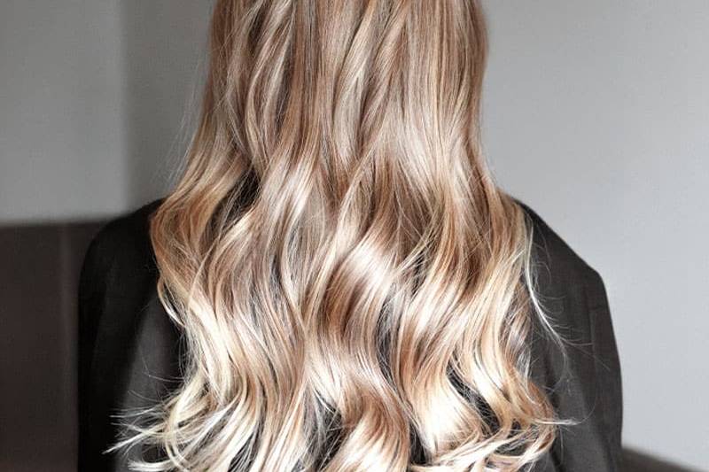 Natürlich wirkende, blonde Strähnchen in langem, gewelltem Haar.