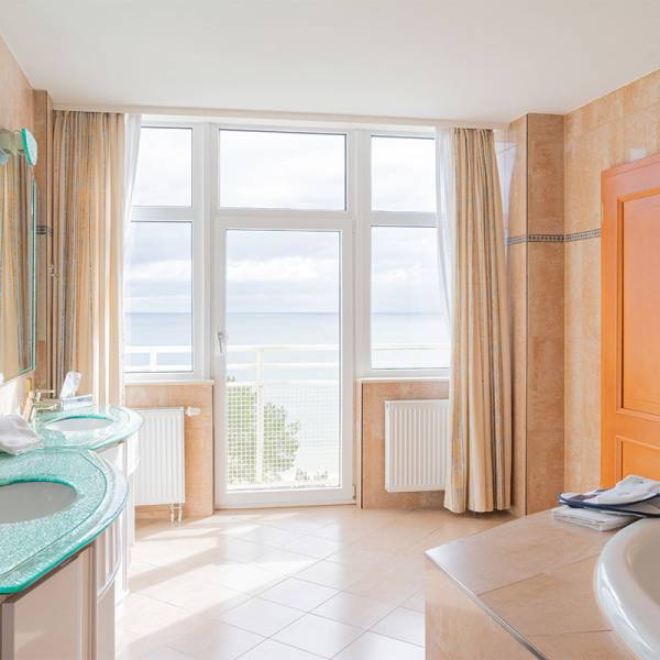 Spacious bathroom in the presidential suite at Arkona Strandhotel Binz with double sinks, a bathtub, and a sea view