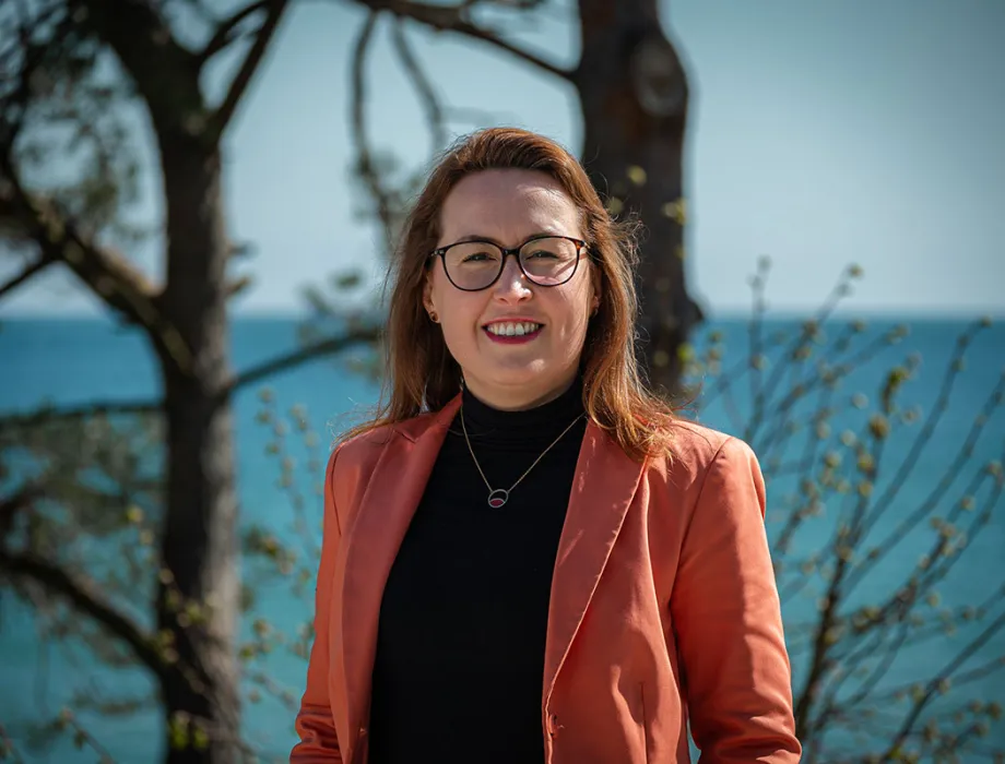 Dorothee Schicht am Strandübergang in Binz bei Sonne – Executive Assistant im Arkona Strandhotel und tragende Stütze im Hintergrund