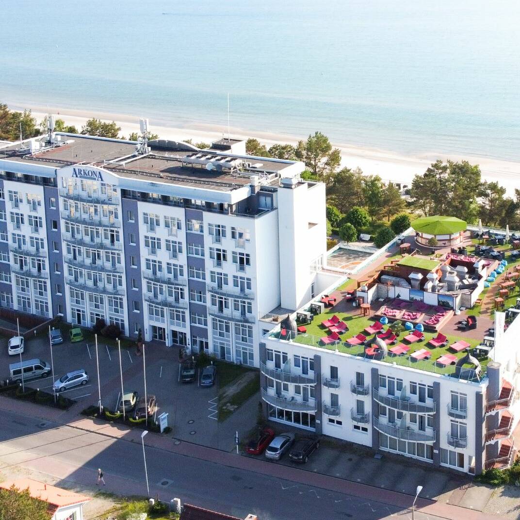 Aufnahme aus der Luft des Arkona Strandhotels mit Dachterrasse und Parkplatz vor dem Hotel