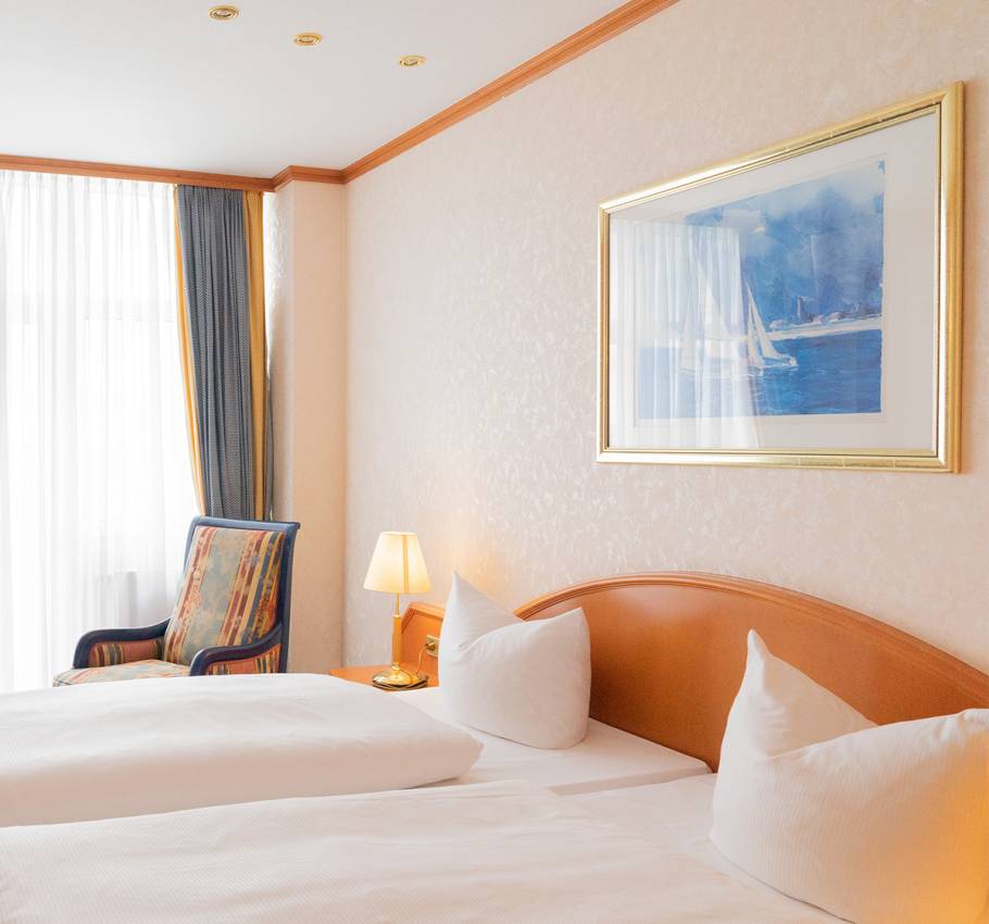 Die Präsidentensuite im Arkona Strandhotel Binz mit elegantem Doppelbett, stilvoller Einrichtung und Blick ins Zimmer