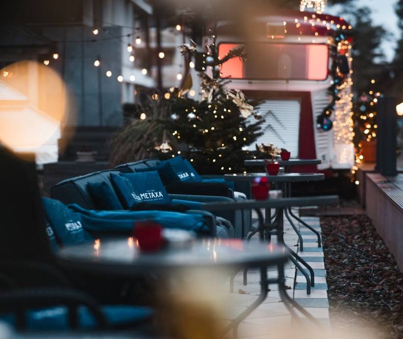Gemütliche Hotelterrasse mit weihnachtlicher Dekoration, Lichterketten, Sitzgelegenheiten und festlicher Atmosphäre in der Adventszeit.