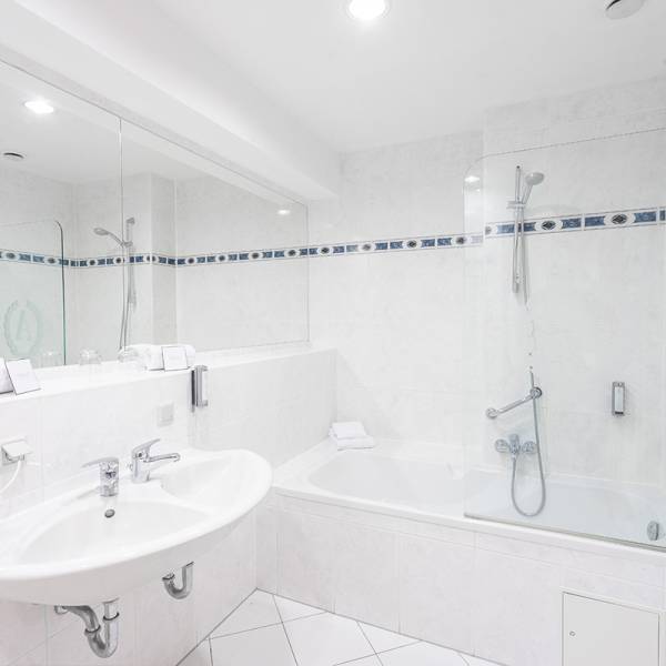 Bathroom of the sea view suite at Arkona Strandhotel Binz featuring a shower and bright tiles