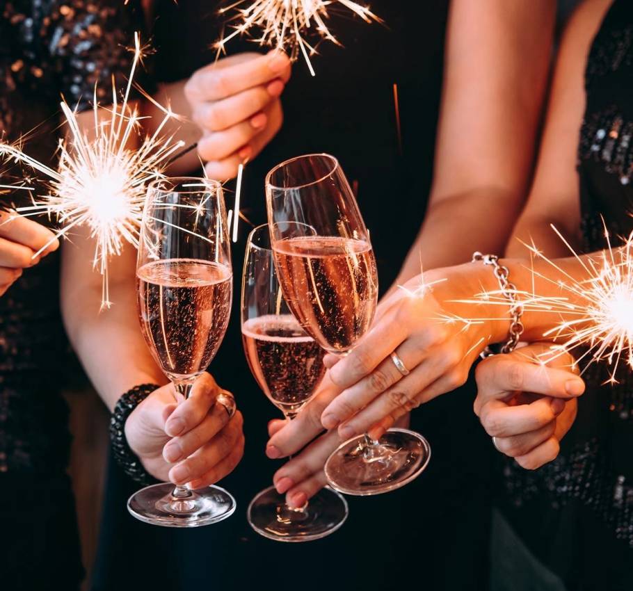 Gäste des Arkona Strandhotels stoßen an Silvester gemeinsam mit Sektgläsern an und halten Wunderkerzen.