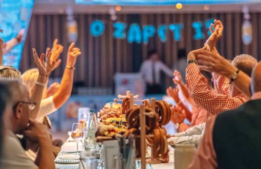 Gäste feiern mit erhobenen Armen beim 4. Binzer Oktoberfest mit traditioneller Kulinarik und festlicher Dekoration im Arkona Strandhotel.