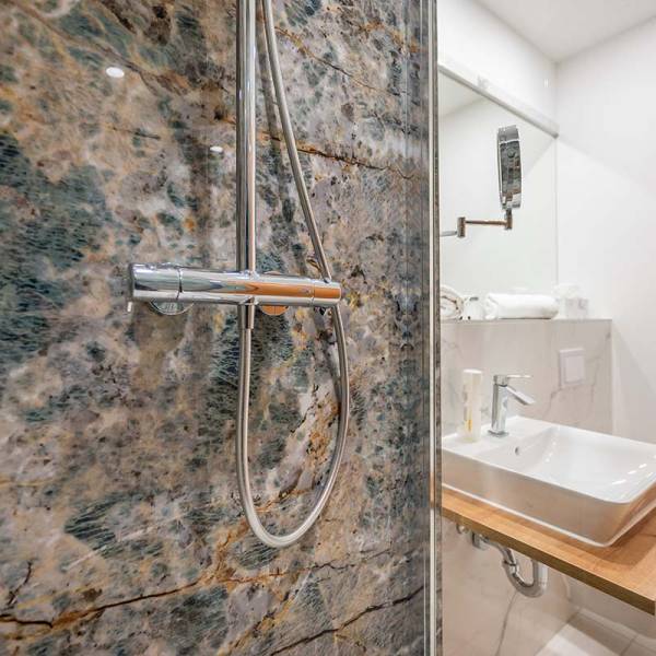 Bathroom at Arkona Strandhotel Binz featuring a modern shower, marble details, and high-quality fixtures.