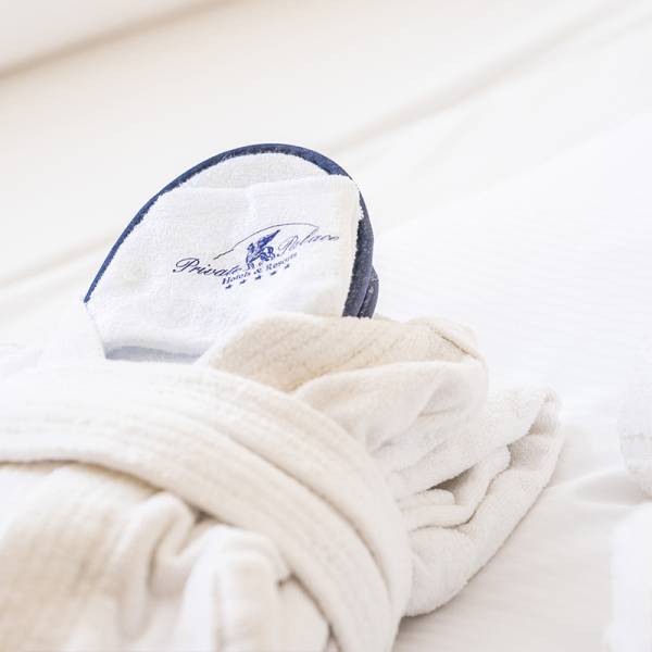 A plush bathrobe with slippers neatly folded on the bed at Arkona Strandhotel Binz.