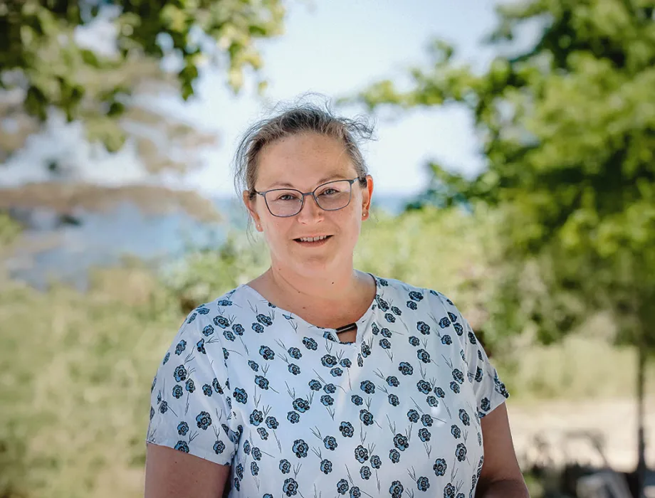 Mandy Lachmann, Leiterin Reservierung im Arkona Strandhotel, lächelnd am Strand von Binz