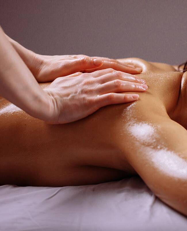 Eine Frau erhält eine Rückenmassage und entspannt sich dabei in einer ruhigen Umgebung.