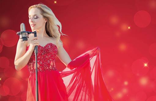 Daria Reich im eleganten, roten Kleid während des Adventskonzertes mit Gala-Menü im Rugard Thermal Hotel in Binz auf Rügen.
