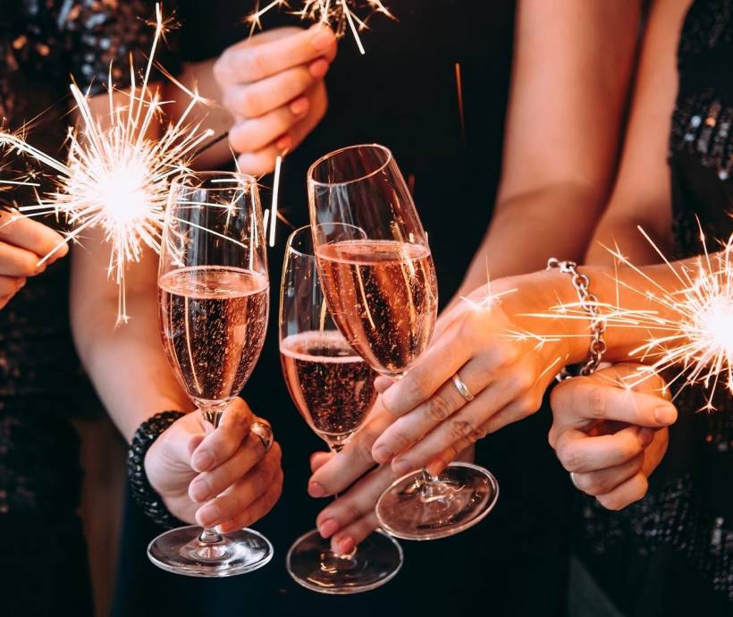 Gäste des Arkona Strandhotels stoßen an Silvester gemeinsam mit Sektgläsern an und halten Wunderkerzen.