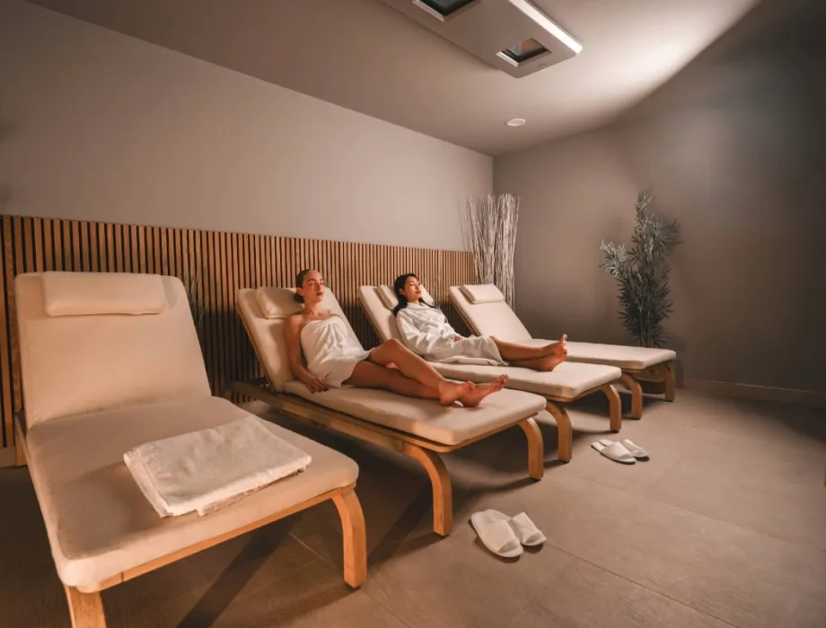 Zwei Damen liegen auf bequemen Liegen im Ruhebereich des Arkona Strandhotels Binz auf Rügen