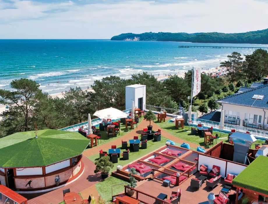 Guests relax on the terrace of the Arkona Sky Bar and enjoy cocktails over the rooftops of Binz.