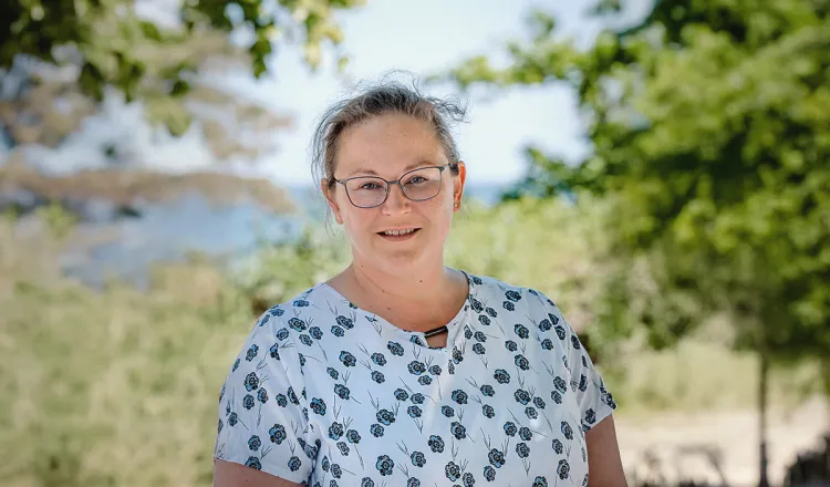 Mandy Lachmann, Leiterin Reservierung im Arkona Strandhotel, lächelnd am Strand von Binz