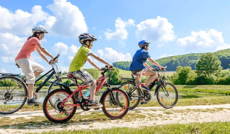 A family enjoys the sunny landscape on a spontaneous bike tour with rental bikes.