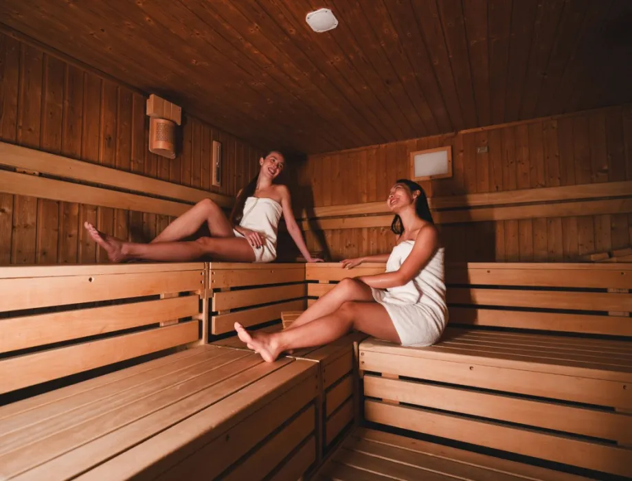 Zwei Damen entspannen in der Sauna im Arkona Strandhotel Binz auf Rügen mit Holzbänken und ruhiger Atmosphäre