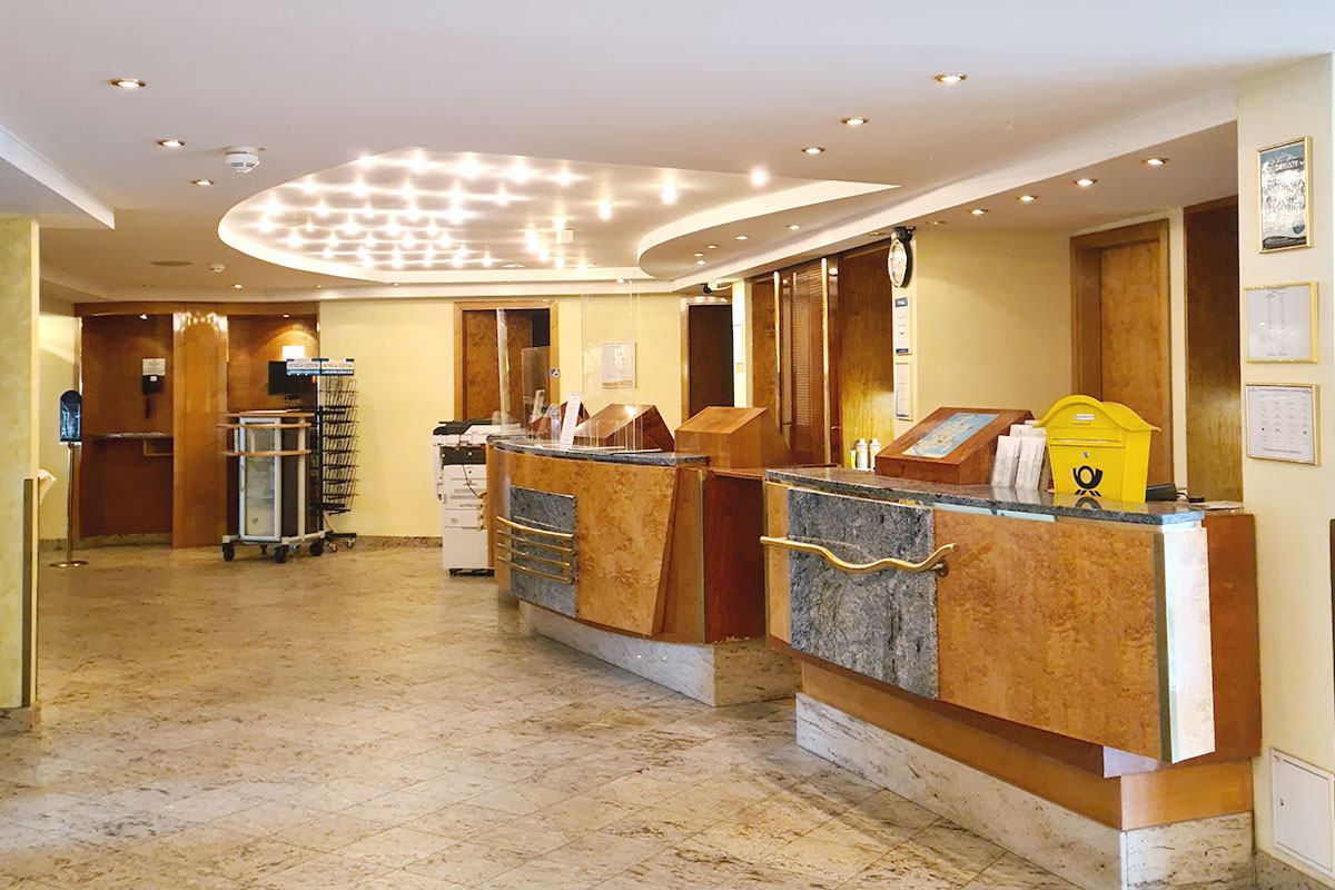 Eine Rezeption im Hotel aus Holz, mit goldenen Details.