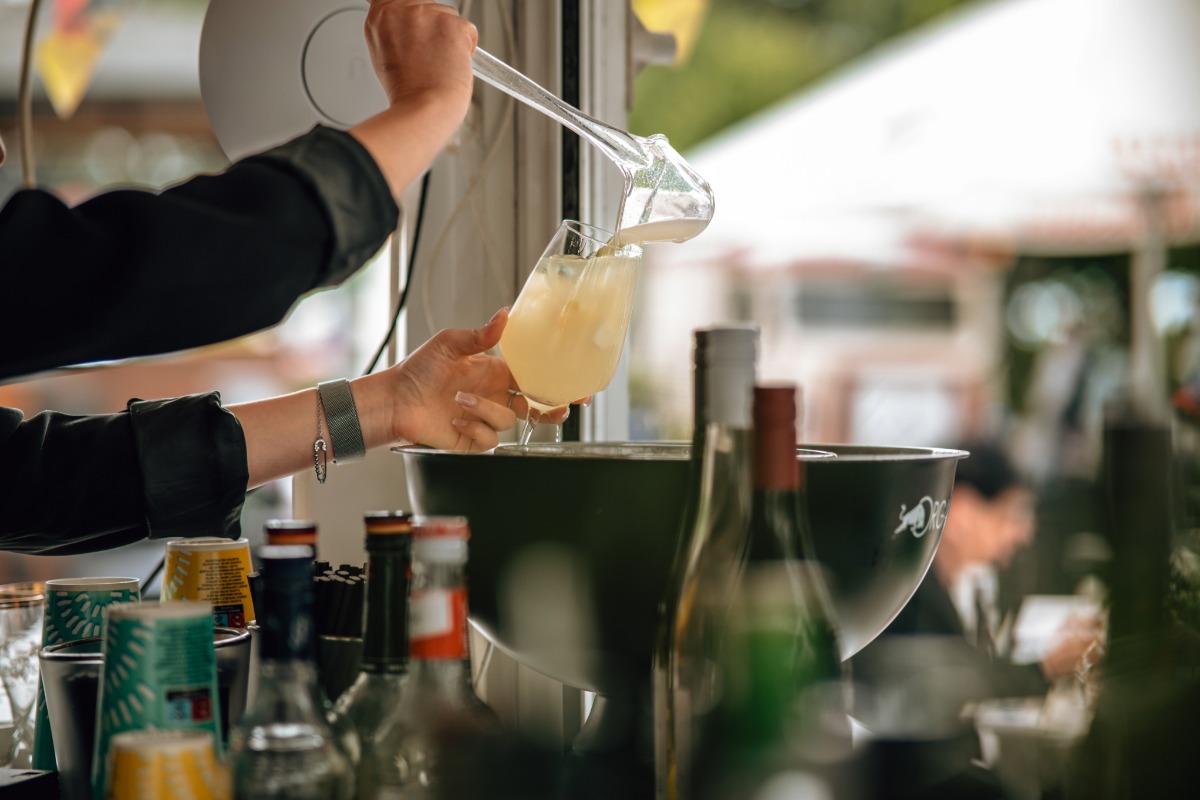 Barkeeperin gießt ein erfrischendes Getränk in ein Glas auf der Arkona Terrasse des Arkona Strandhotels auf Rügen