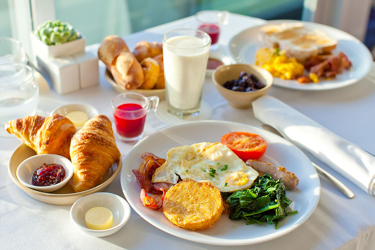 Ein Tisch auf dem ein üppiges Frühstück auf zwei Tellern angerichtet ist.