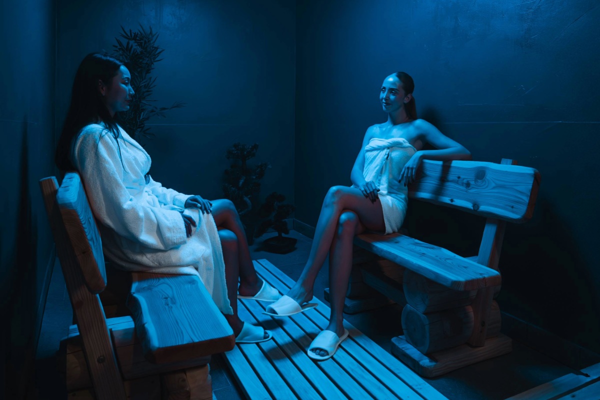 Two women relaxing in the ice room at Arkona Strandhotel Binz on Rügen on wooden benches in cool temperatures