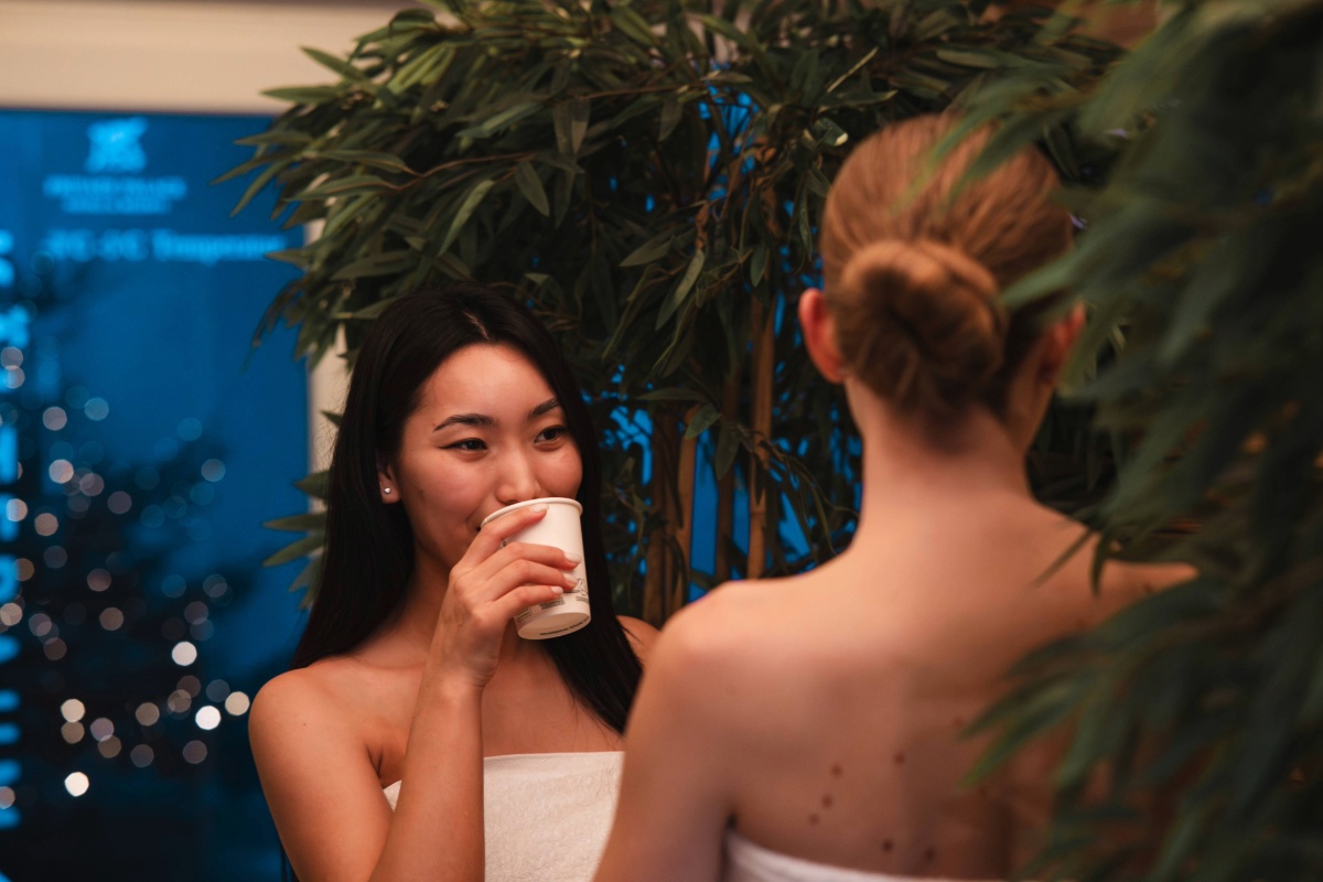 Two women enjoying a cup of tea in the wellness area at Arkona Strandhotel Binz on Rügen between pool and sauna