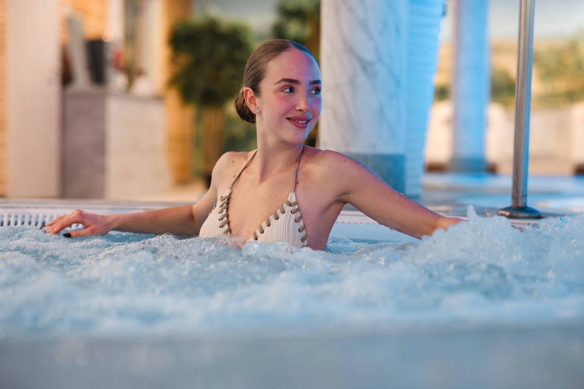 Woman relaxing in the whirlpool at Arkona Strandhotel Binz on Rügen with bubbling water in the wellness area