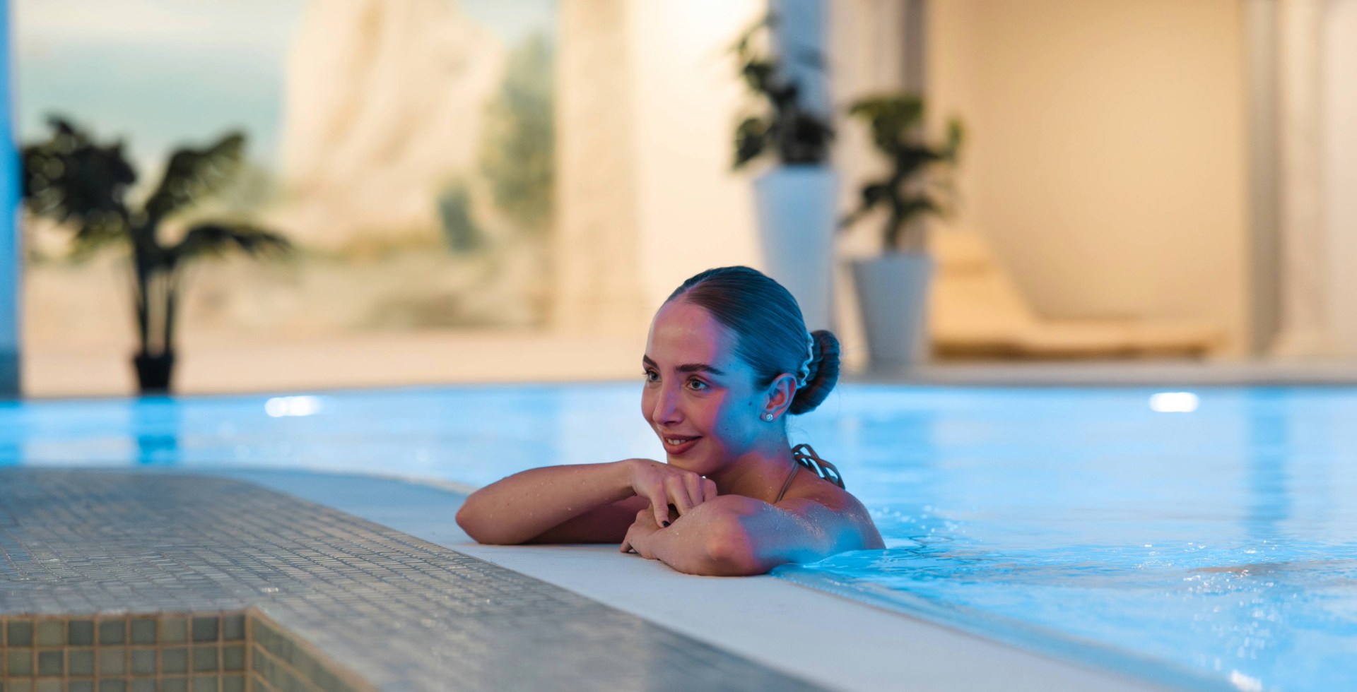 Woman resting at the pool edge in the wellness area at Arkona Strandhotel Binz on Rügen