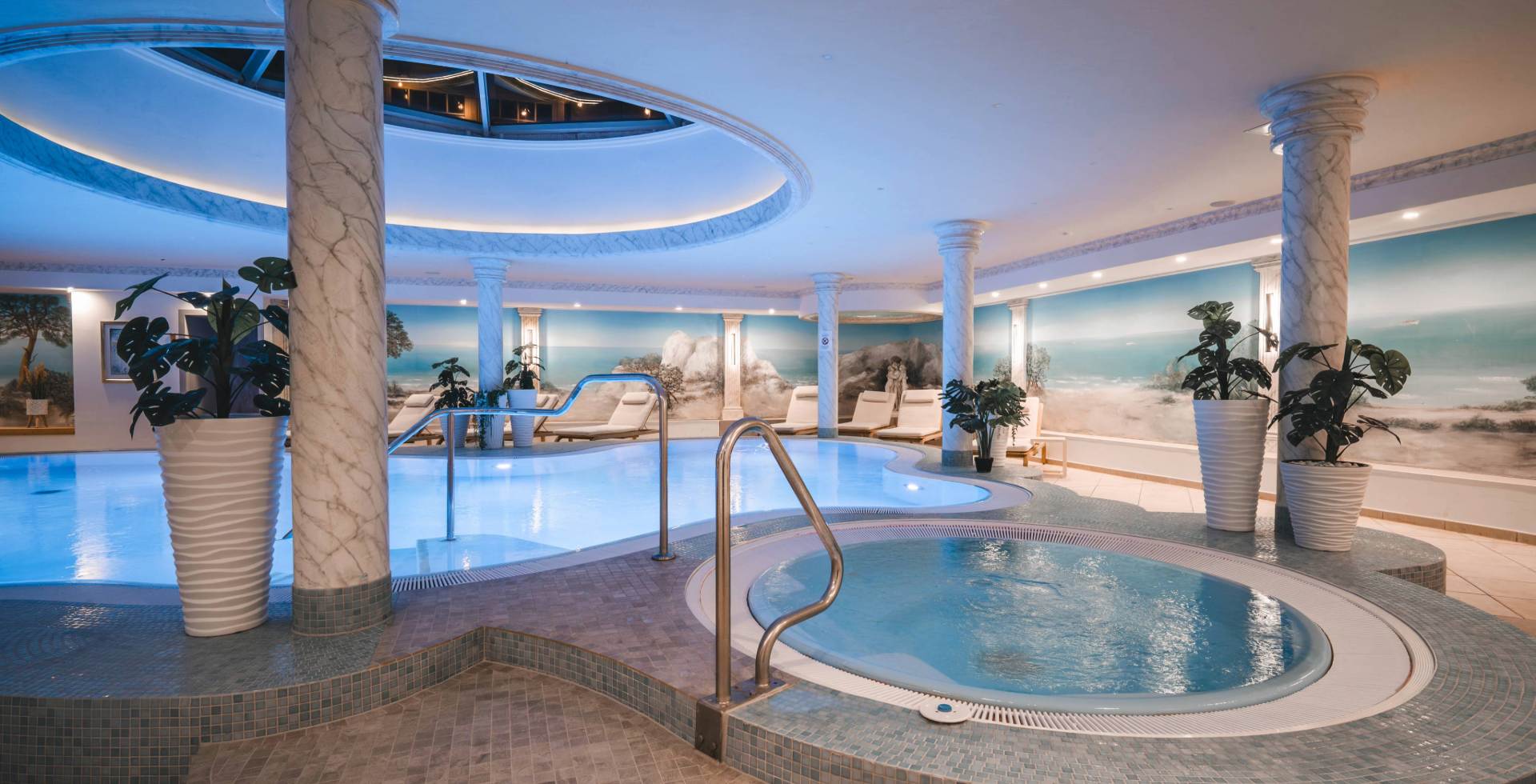 Pool and whirlpool in the wellness area at Arkona Strandhotel Binz on Rügen with columns, loungers and water access